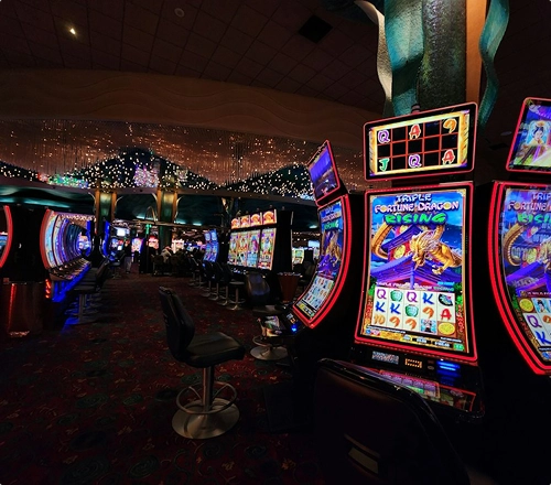 A casino hall containing rows of illuminated electronic gaming machines.