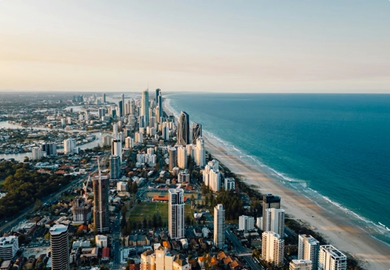 An aerial view of the Surfers Paradise skyline and coastline beside the ocean.