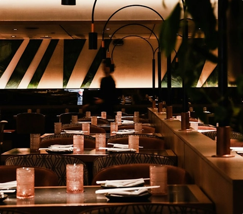 A warm and elegant restaurant interior with softly lit tables, modern décor, and an intimate evening atmosphere.
